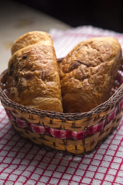 Chocolate croissants in a basket — Stock Photo, Image