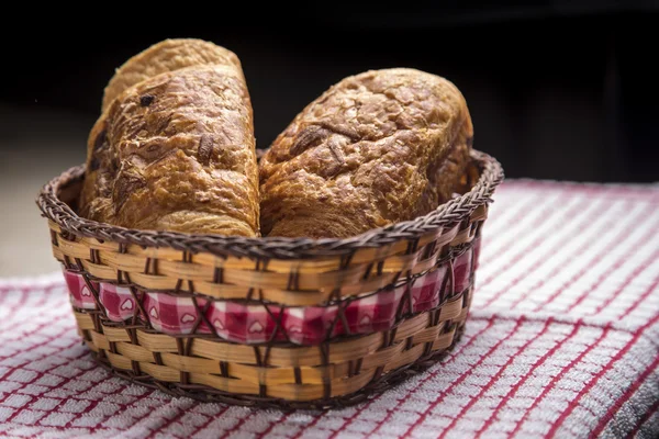 Chocolate croissants in a basket — Stock Photo, Image