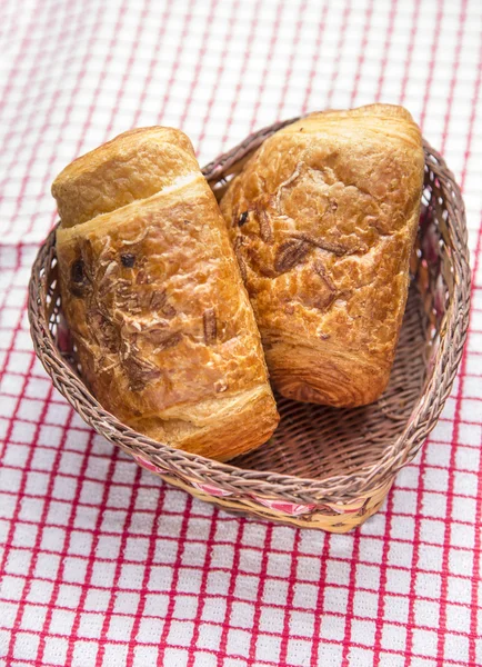 Chocolate croissants in a basket — Stock Photo, Image