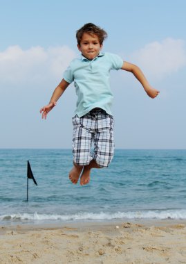 7 years old boy jumping in the sea
