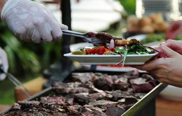 Kokkens hender, sett kjøtt på tallerkenen – stockfoto