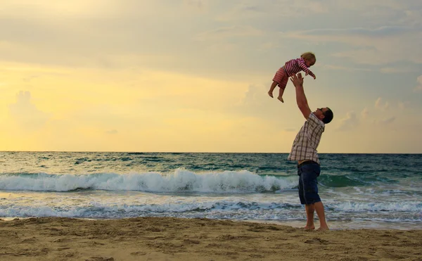 Père et fille jouent ensemble sur la plage au coucher du soleil — Photo