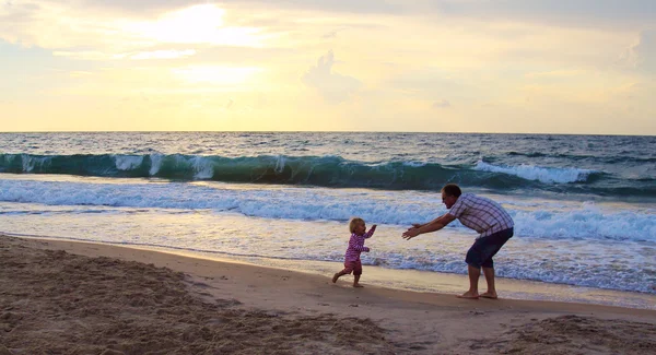 Baba ve kızı birlikte gün batımında sahilde oynarken — Stok fotoğraf