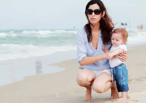 Мать и маленький ребенок веселятся на пляже — стоковое фото