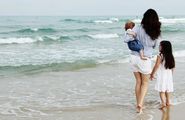 Mutter mit zwei Töchtern am Strand — Stockfoto