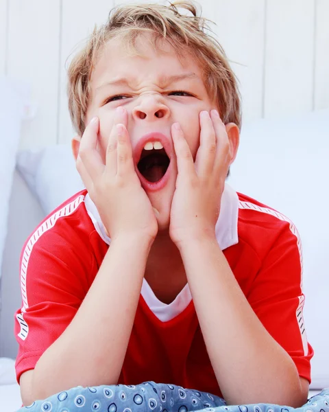 Милый мальчик зевает — стоковое фото
