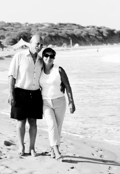 Ευτυχής ανώτερος ζεύγος που περπατά μαζί σε μια παραλία — Φωτογραφία Αρχείου