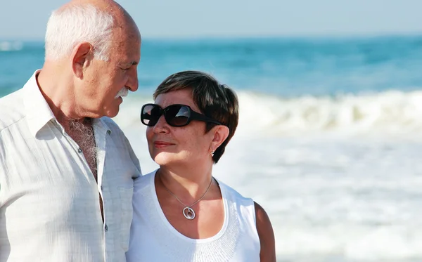 Heureux couple de personnes âgées marchant ensemble sur une plage — Photo