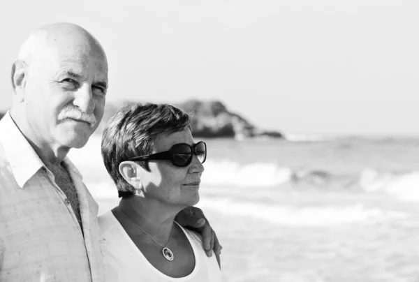 Casal sênior feliz andando juntos em uma praia — Fotografia de Stock