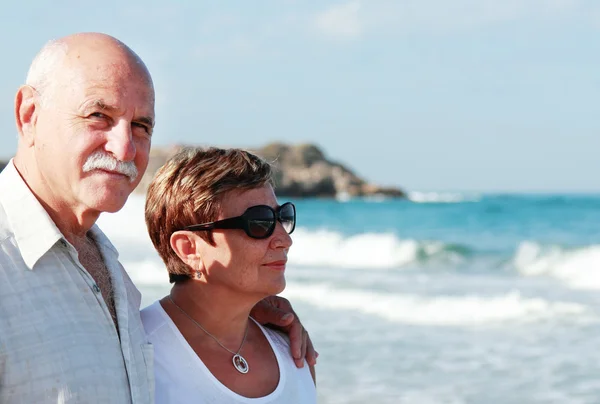 Happy senior couple walking together on a beach — Stock Photo, Image