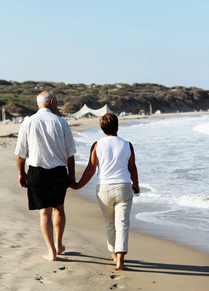Ευτυχής ανώτερος ζεύγος που περπατά μαζί σε μια παραλία — Φωτογραφία Αρχείου