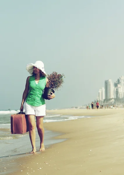 Mujer joven con un árbol y una maleta vintage caminando sobre el ed — Foto de Stock