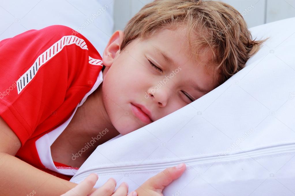 Cute 7 years boy sleeping on white pillow in summer cafe — Stock Photo