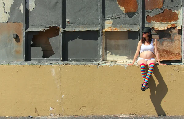 Mujeres embarazadas en calcetines de colores sentados en la valla — Foto de Stock