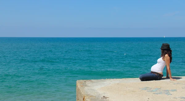 Jeune femme enceinte contre la mer bleue — Photo