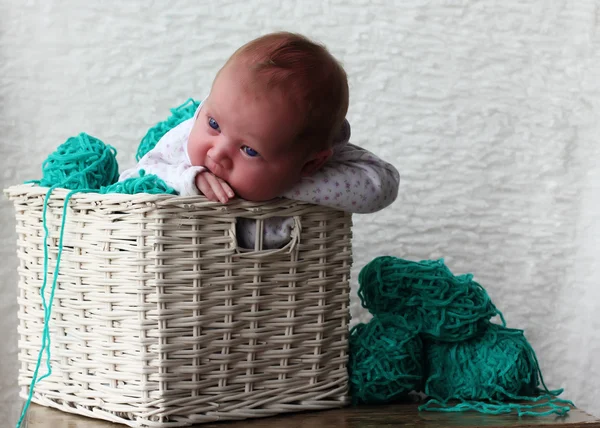 Menina recém-nascida em uma cesta com fio — Fotografia de Stock