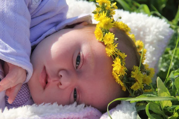 Menina de um mês deitada na grama ao lado das papoilas vermelhas — Fotografia de Stock