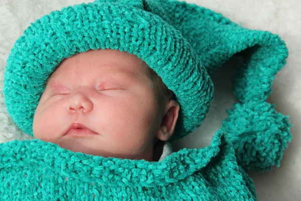 Recém-nascido em um casulo de malha e chapéu — Fotografia de Stock