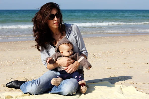 Mor med sitt barn på stranden — Stockfoto