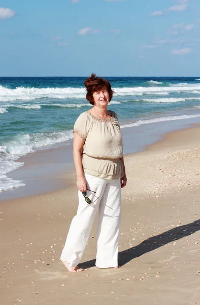 快乐的老年女子在海滩上 — 图库照片