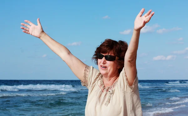 Ευτυχισμένη ηλικιωμένη γυναίκα στην παραλία — Φωτογραφία Αρχείου