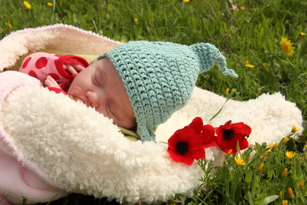Month-old girl lying on white blanket next to the red poppies — Stock Photo, Image