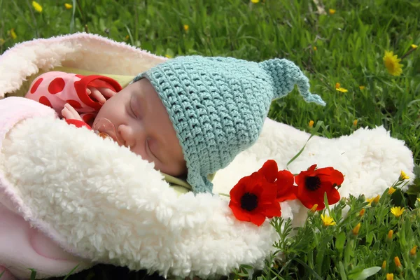 Meisje van de maand-oude liggend op witte deken naast de rode papavers — Stockfoto