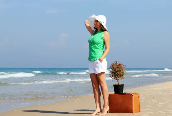 Hermosa chica con maleta vintage en la playa — Foto de Stock