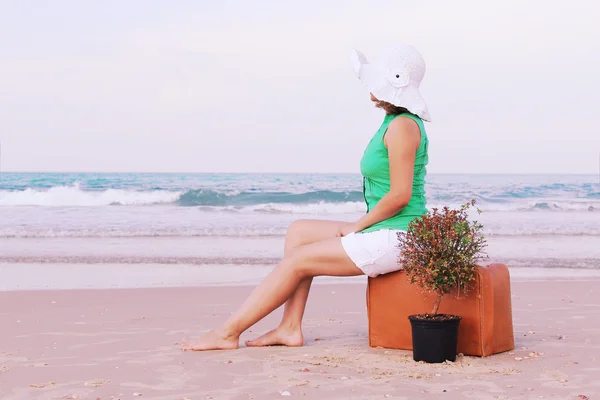 Menina bonita com mala vintage na praia . — Fotografia de Stock