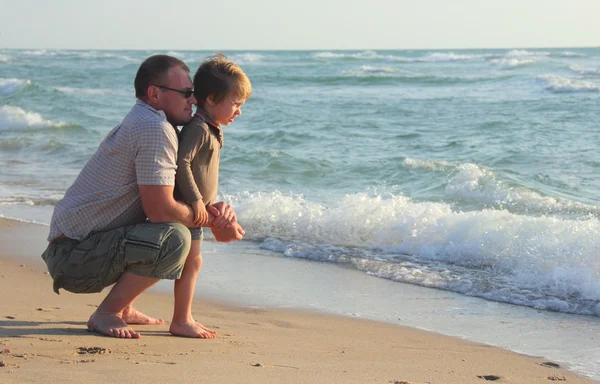 Barn och hans far på stranden — Stockfoto