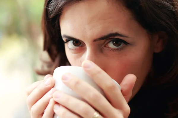 Una joven con una taza de café. Concéntrate en los ojos . — Foto de Stock