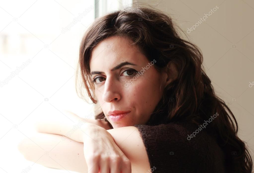 beautiful 35 year old woman stands in front of the window