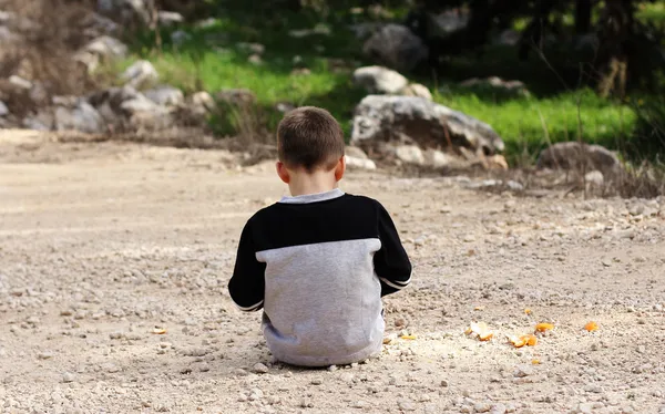 Niño triste sentado solo en la naturaleza, síndrome de autismo —  Fotos de Stock