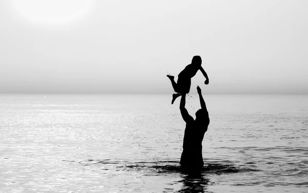 Padre e hijo en el mar al atardecer — Foto de Stock