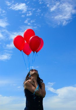 kadın kırmızı balonlar ile