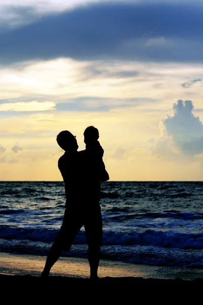 Far och dotter spelar tillsammans på stranden vid solnedgången — Stockfoto