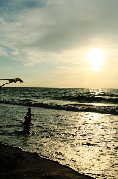 Kinderen spelen met kite op de zee — Stockfoto