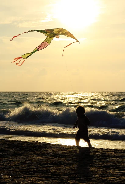 Kind spelen met kite op de zee — Stockfoto