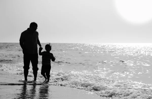 父と息子夕焼けの海に — ストック写真