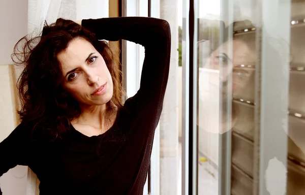 Portrait of beautiful woman near the window — Stock Photo, Image