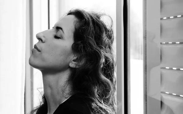 Pencerenin yanında güzel bir kadın portresi — Stok fotoğraf