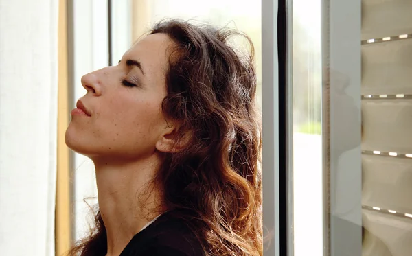 Porträt einer schönen Frau am Fenster — Stockfoto