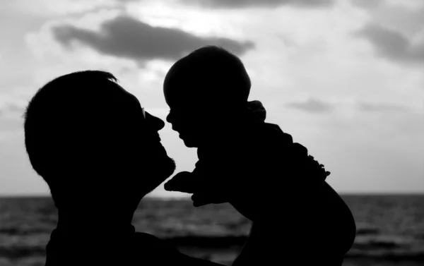 Baba ve kızı gün batımında sahilde oynarken — Stok fotoğraf