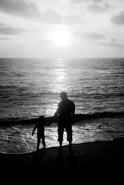 Father and son on a walk by the sea at sunset — Stock Photo, Image