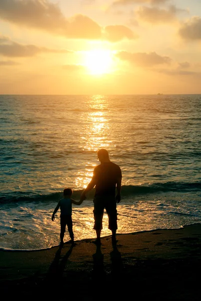 Father and son on a walk by the sea at sunset — Stock Photo, Image