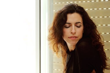 pencerenin yanındaki güzel 35 yaş yaşlı kadın portresi