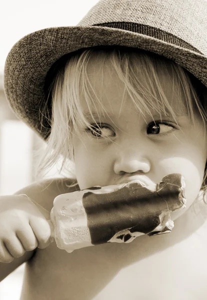 Leuk meisje in de hoed eten van ijs — Stockfoto