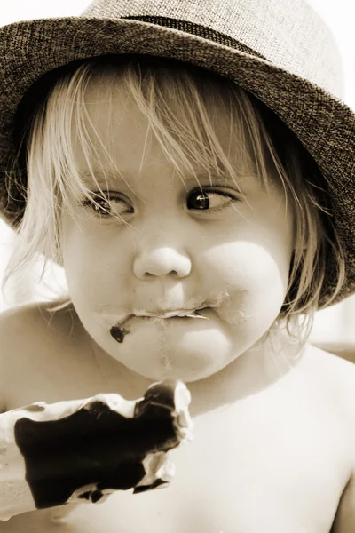 Leuk meisje in de hoed eten van ijs — Stockfoto