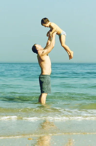 Glücklicher Vater und Sohn am Strand. Foto in alter Bildfarbe. — Stockfoto