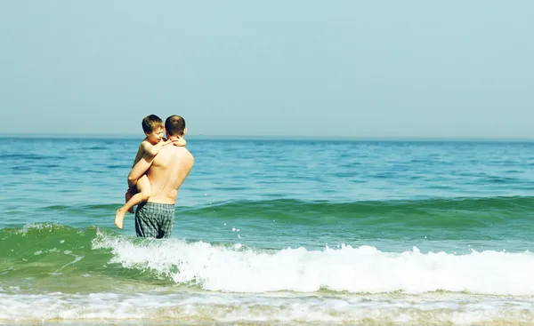 Отец и сын собираются купаться в море — стоковое фото
